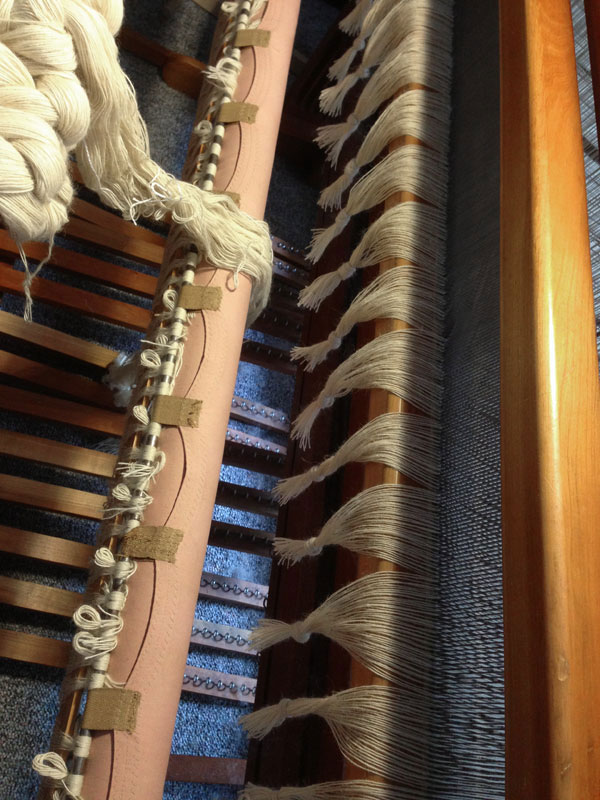 The blankets were cut off and the old warp threads were bundled into groups to prevent from slipping back through the reed.