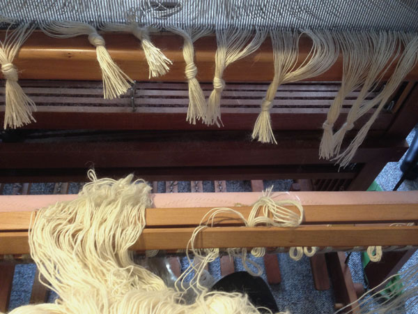 The new warp is held in place with two lease sticks. Maintaining the cross and freeing up my hands to tie the knots.