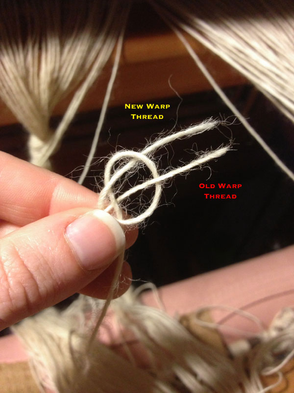 I slide the loop I've created over the tip of my thumb and pull the old warp thread through the loop.